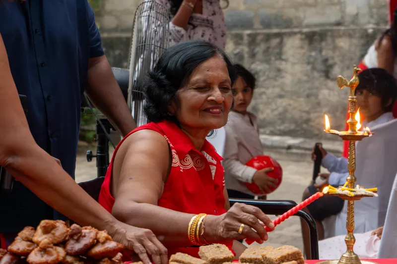 A resident in red lights a candle at the New Year oil lamp
