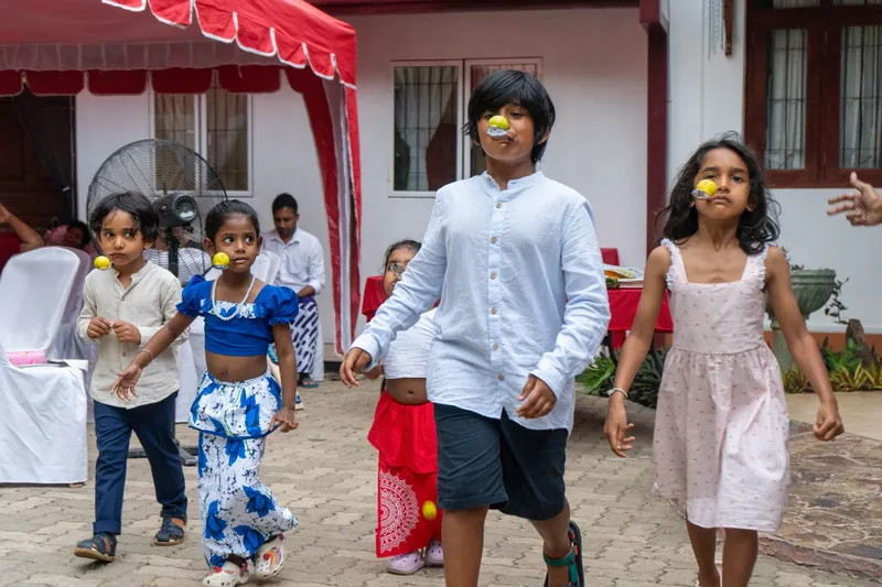 Children walking carefully with limes balanced on spoons in their mouths