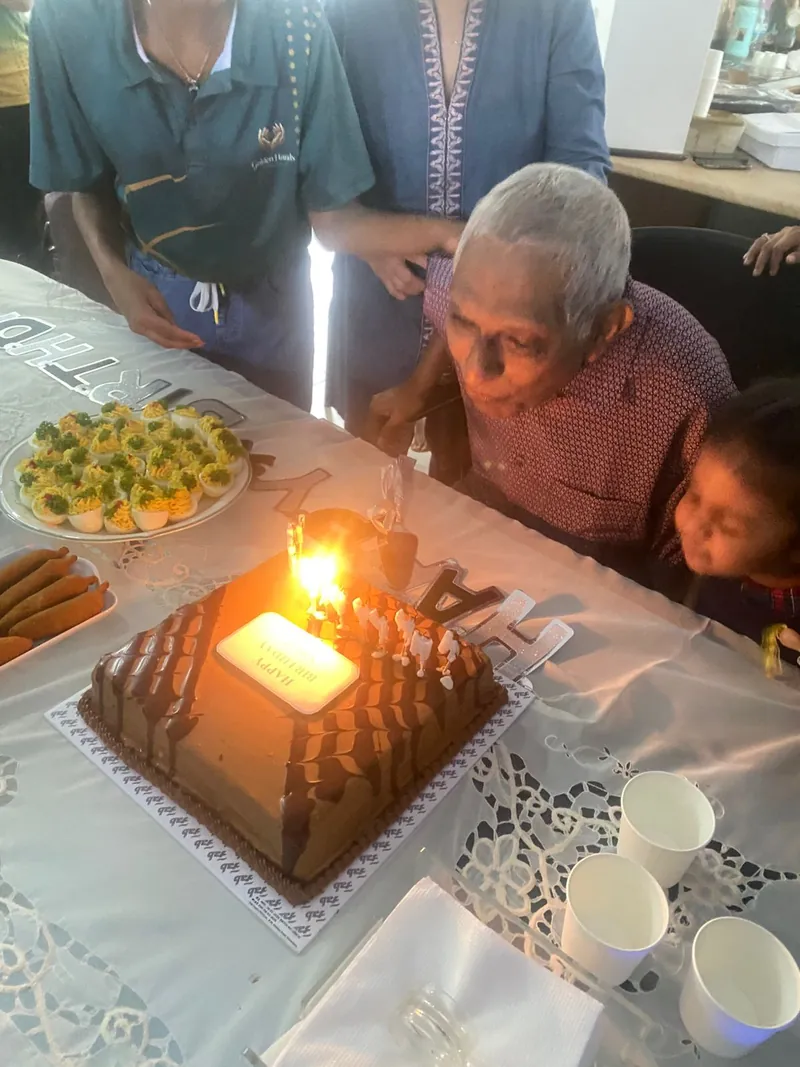 A resident blows out the candle on his birthday cake