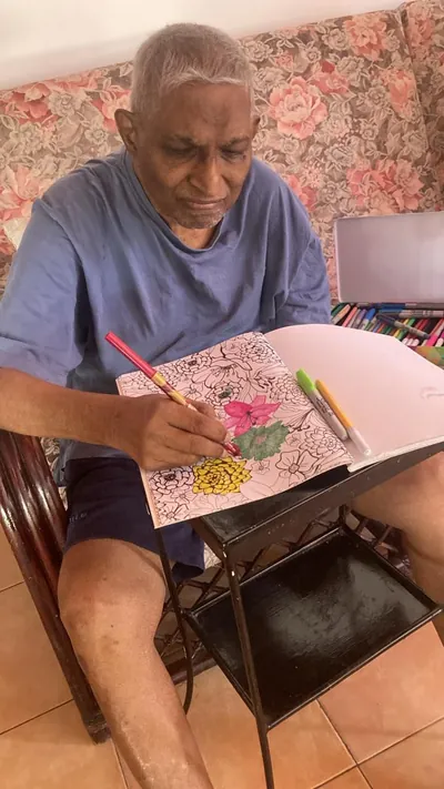 A resident colouring flowers in a colouring book with markers