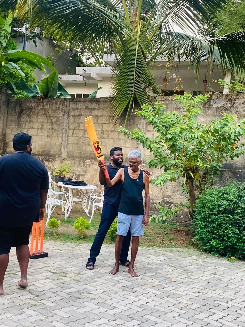 Dr. Vasika and a resident raise the cricket bat in celebration