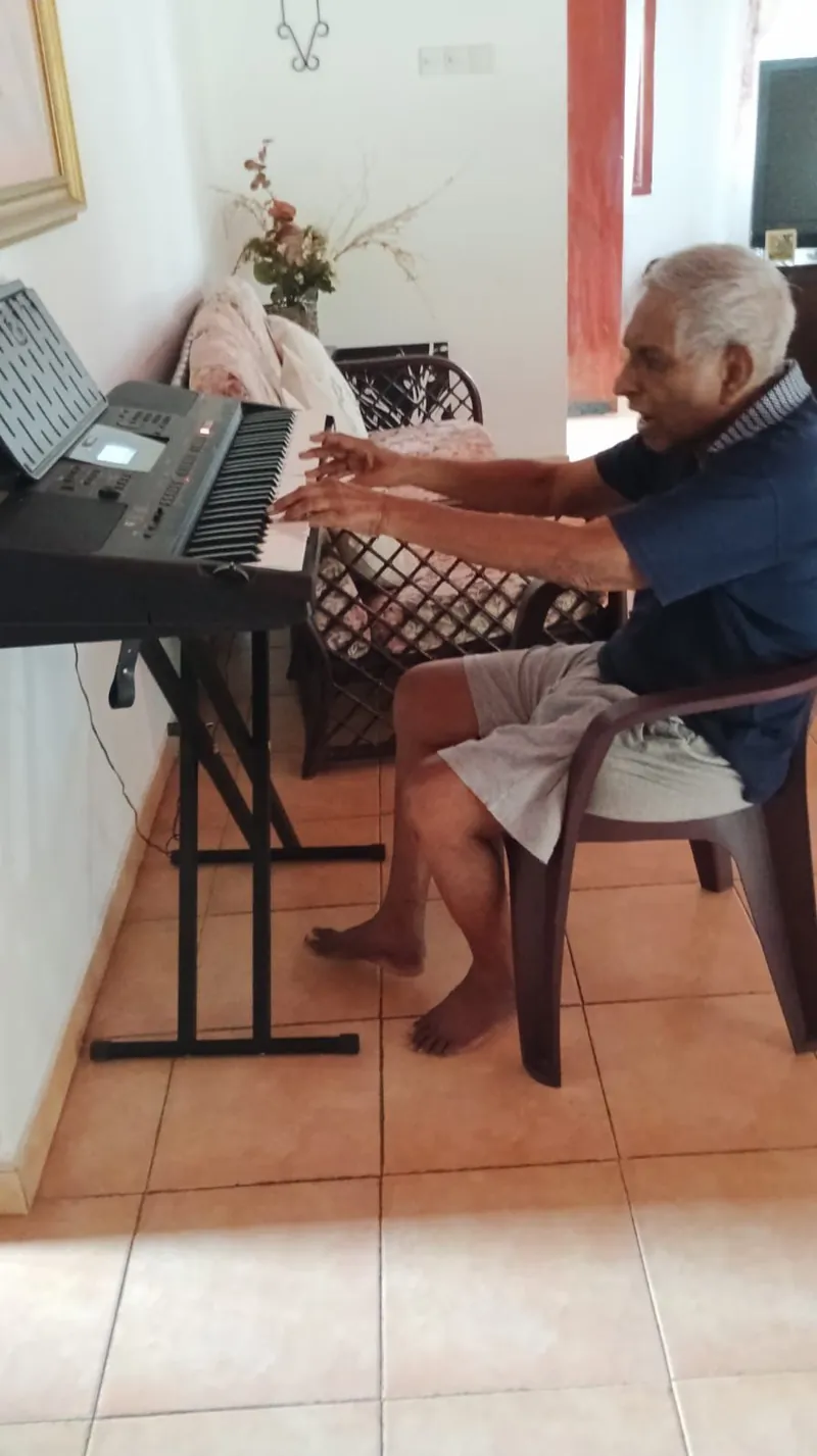 A resident playing an electronic keyboard by the window