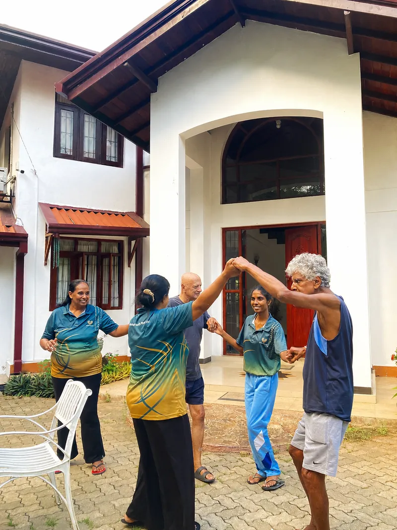Residents and caregivers exercising together in the front courtyard