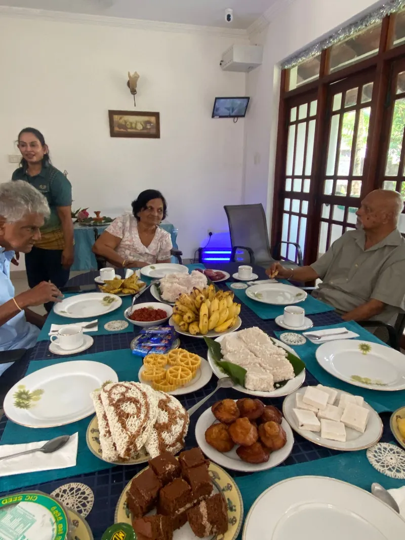 Residents seated around a table laden with traditional New Year sweets