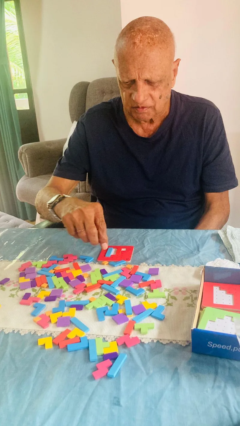 A resident solving a colourful block puzzle at the table