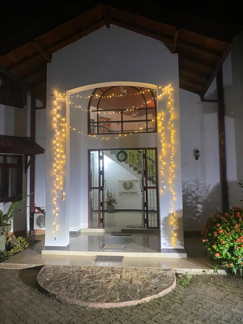 The home's entrance at night, framed with warm fairy lights and a wreath on the door